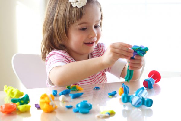 Девочка играет с развивающей игрушкой