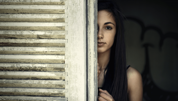 Девушка прячется за дверью
