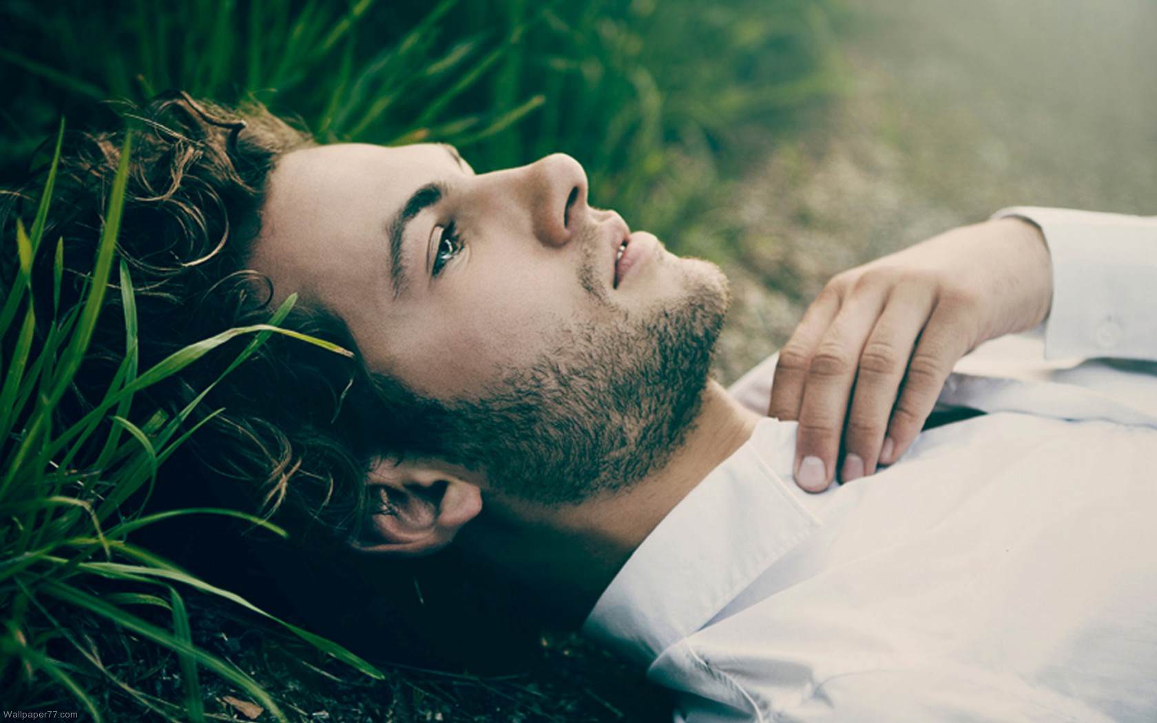 Размышления на сегодня. Парень лежит на траве. Мечтательный мужчина. Парень на траве. Мужчина мечтает.