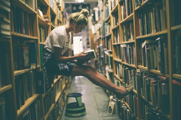 Девушка читает в библиотеке
